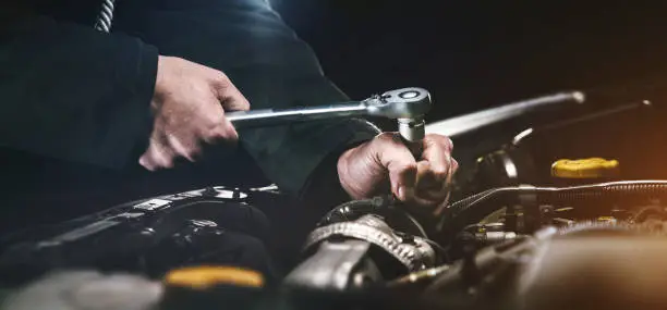 Mechanic inspecting under a car on a lift at Maxim Motors Dún Laoghaire